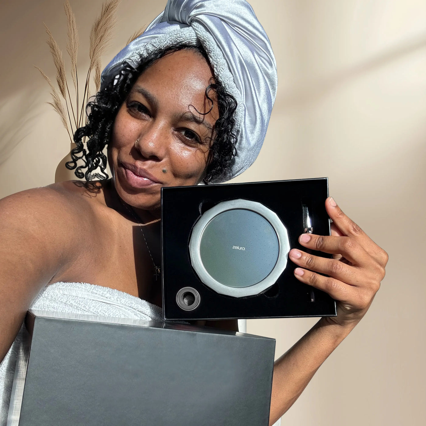 Woman with natural curls using the Zelura filtered showerhead